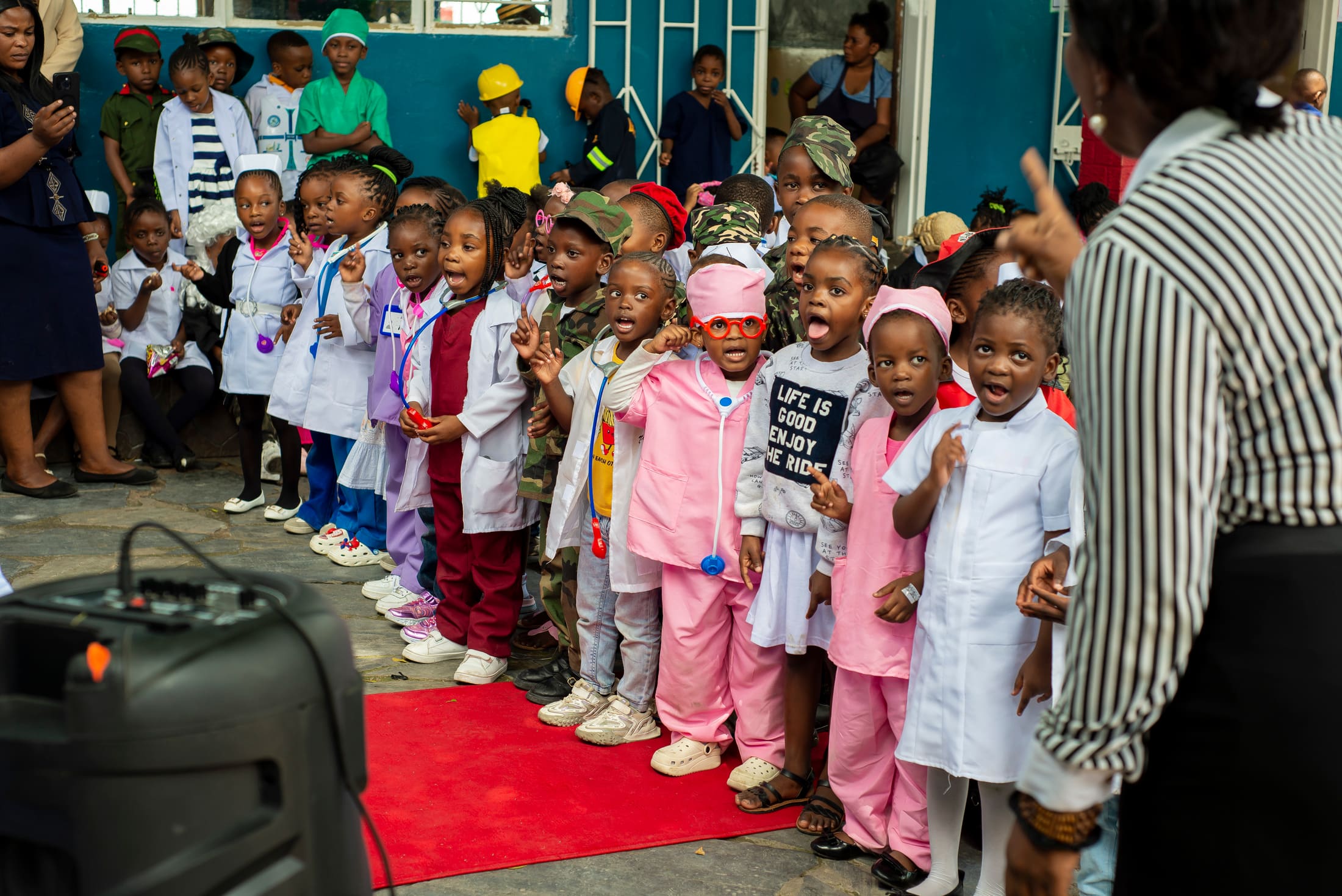 Tukiya pupils gathered on stage at a school event