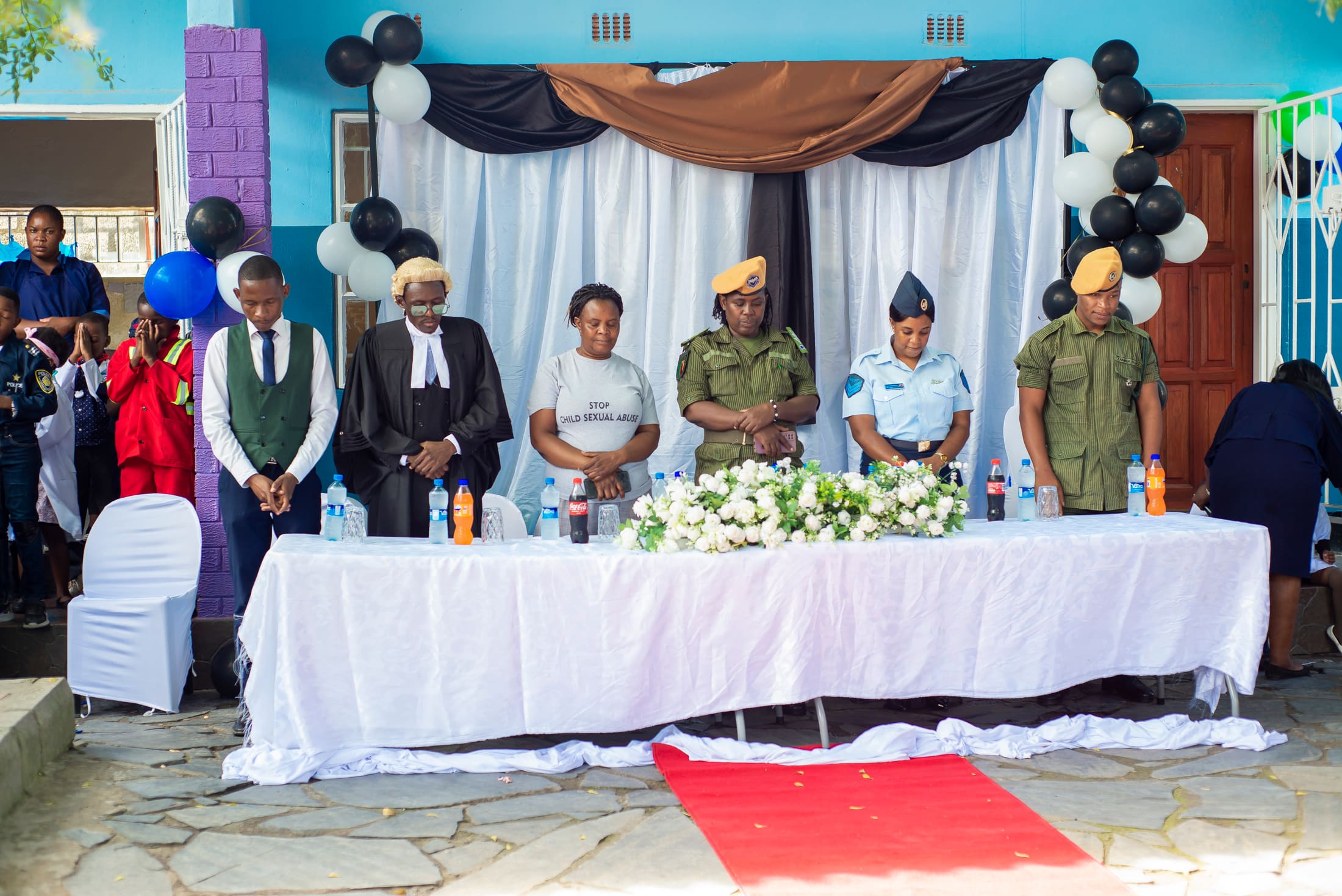 Community professionals standing with Tukiya pupils