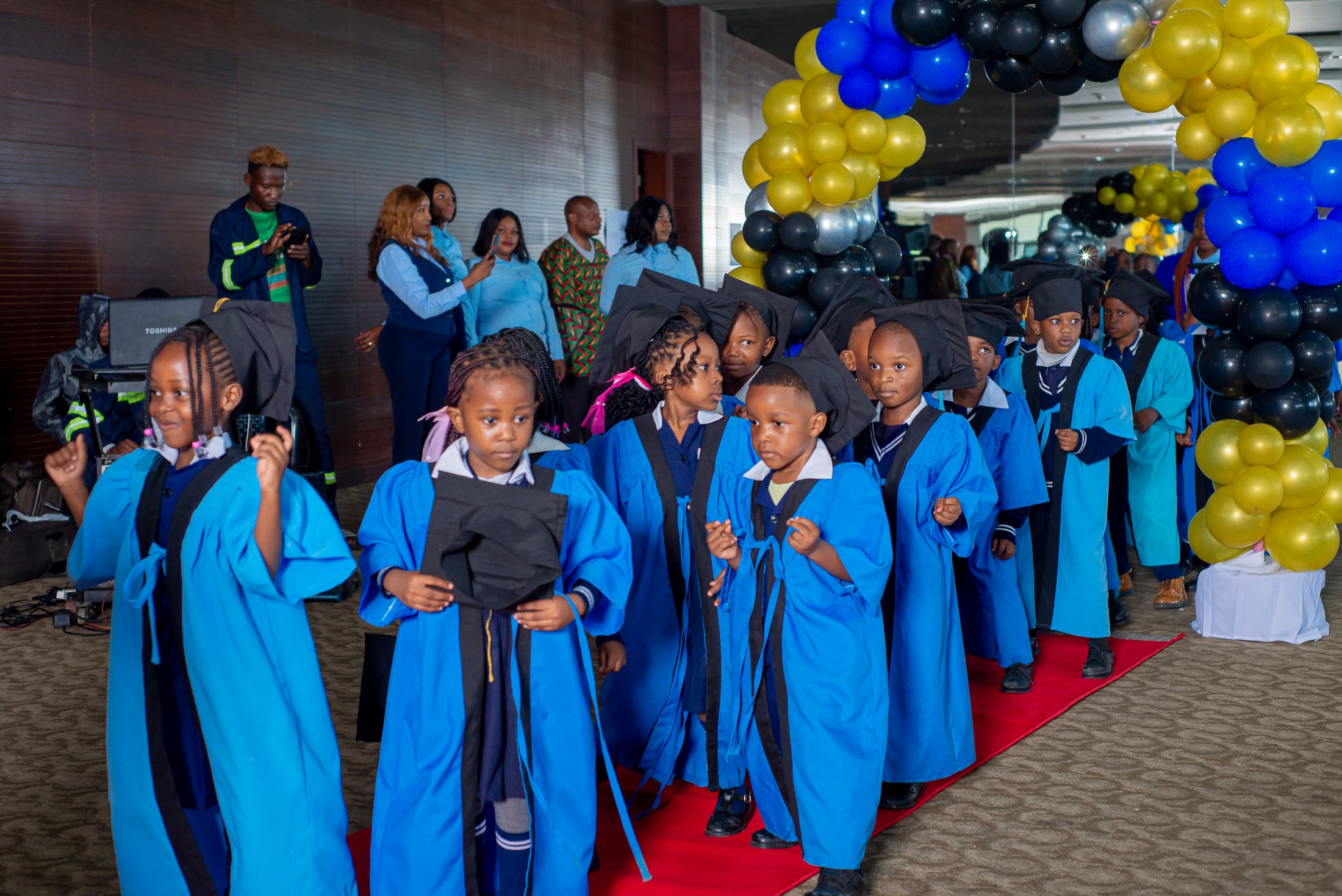 Graduates walking the red carpet in cap and gown